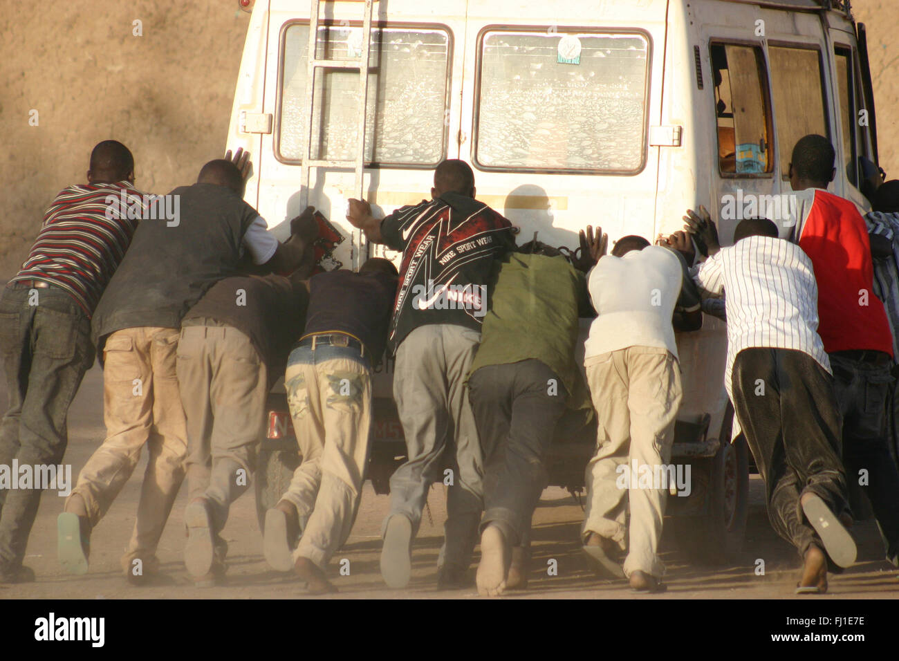 Eine Gruppe von schwarzen Mann zusammen schieben, aufgeschlüsselt Fahrzeug in Djenné, Mali Stockfoto
