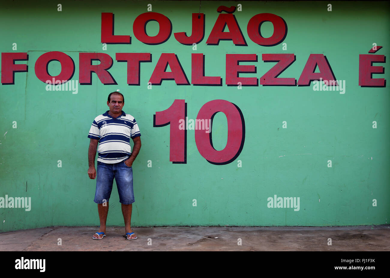 Mann in Barreirinhas mit 'Lojão Fortaleza" Schreiben an Wand, Maranhao, Brasilien Stockfoto