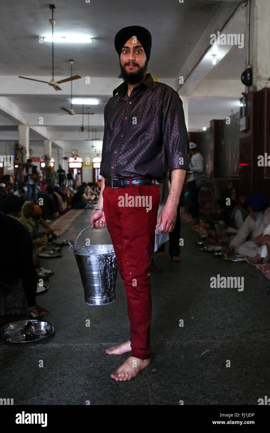 Sikh Mann freiwillig Essen in Kantine in Golden Temple Harmandir Sahib, Amritsar, Punjab, Indien Stockfoto