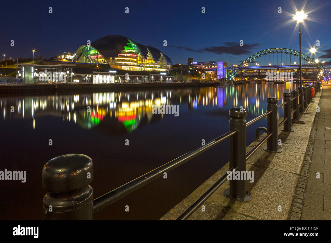 Ein Blick auf die Sage Gateshead und HMS Calliope Royal Navy Reserve auf Gateshead Quays in der Nacht von Newcastle Quayside angesehen Stockfoto