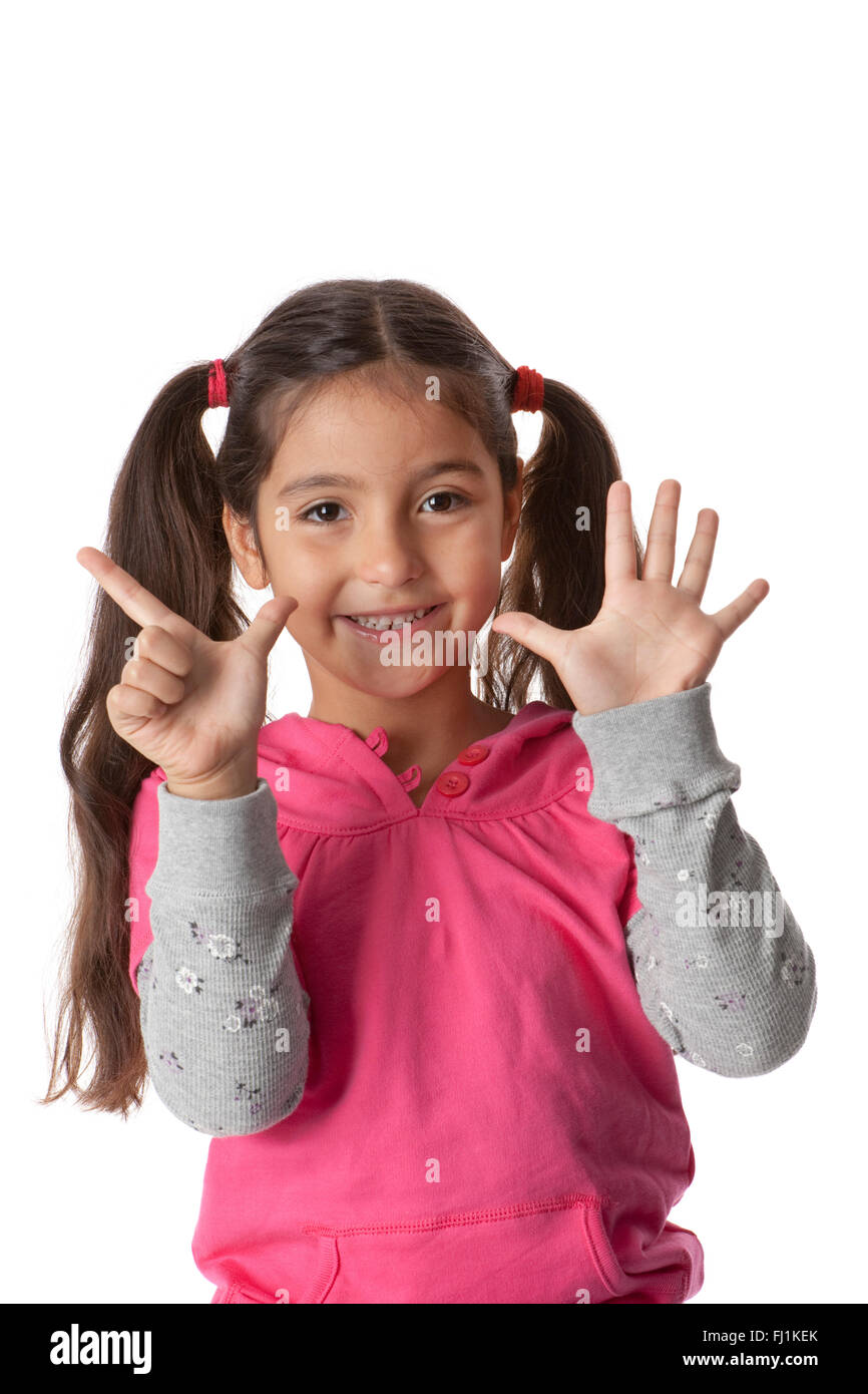 Kleines Mädchen zeigt 7 Finger auf weißem Hintergrund Stockfoto