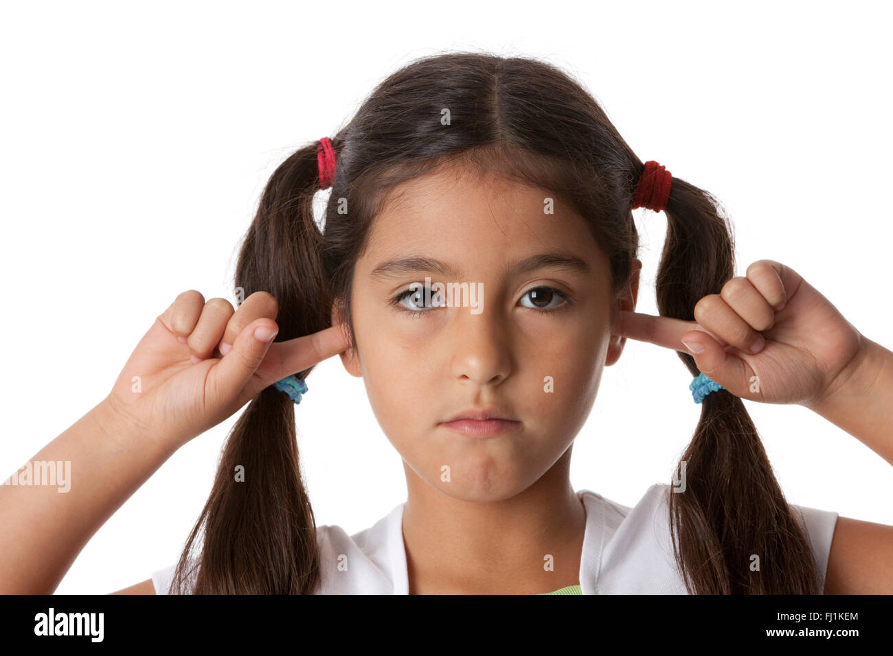 Kleines Mädchen schließt ihre Ohren mit den Fingern auf weißem Hintergrund Stockfoto