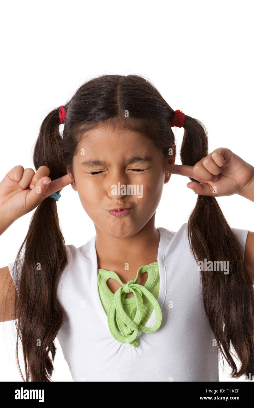 Kleines Mädchen schließt ihre Ohren mit den Fingern auf weißem Hintergrund Stockfoto