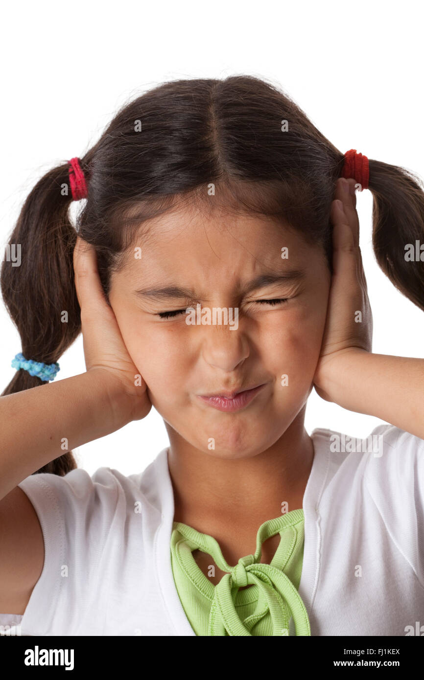 Kleines Mädchen schließt ihre Ohren mit den Händen auf weißem Hintergrund Stockfoto