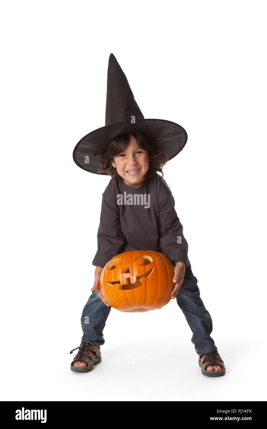 Kleiner Junge hebt einen Halloweenkürbis auf weißem Hintergrund Stockfoto