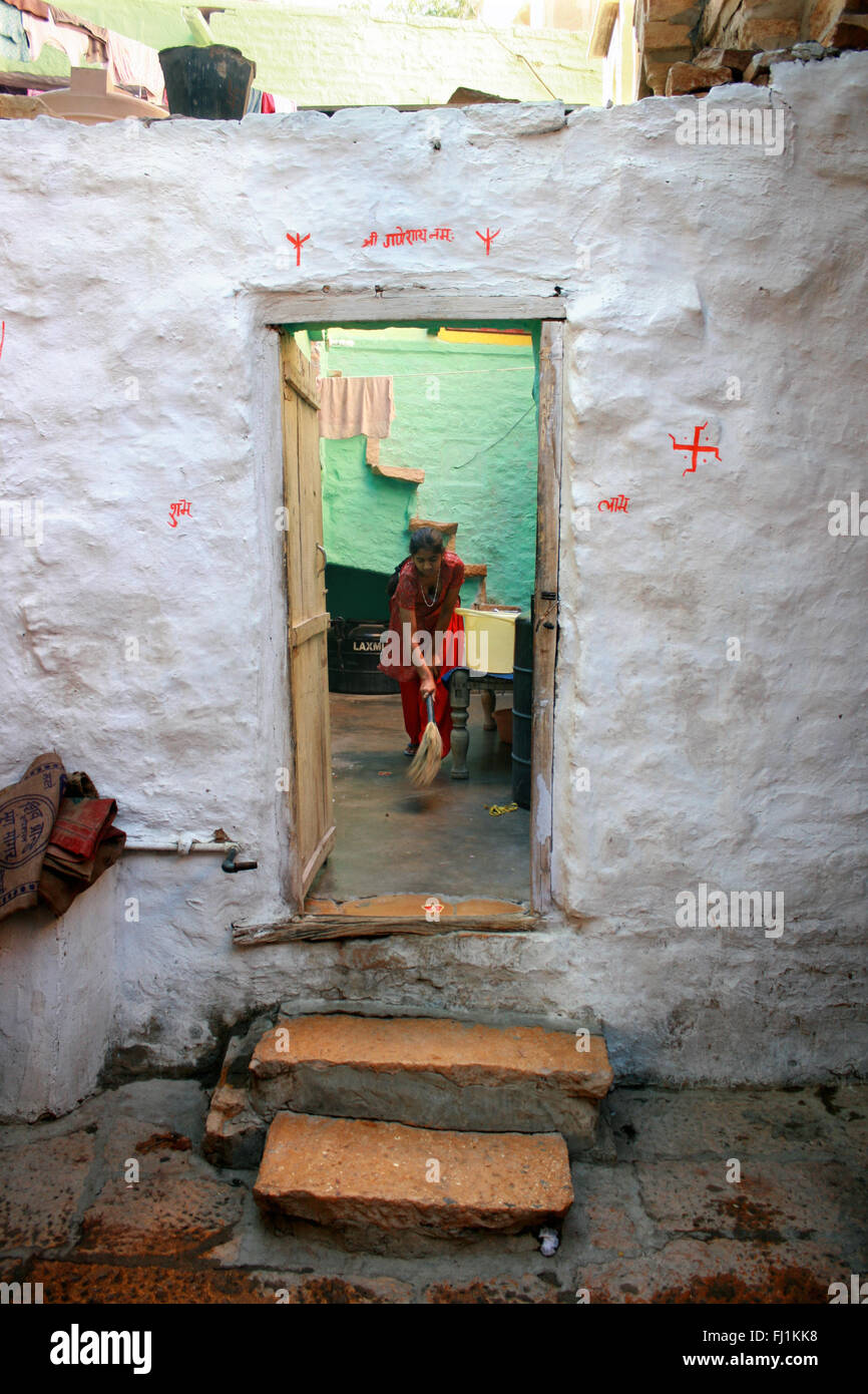 Frau Reinigung im Innenhof ihres Hauses in Jaisalmer Fort, Indien Stockfoto