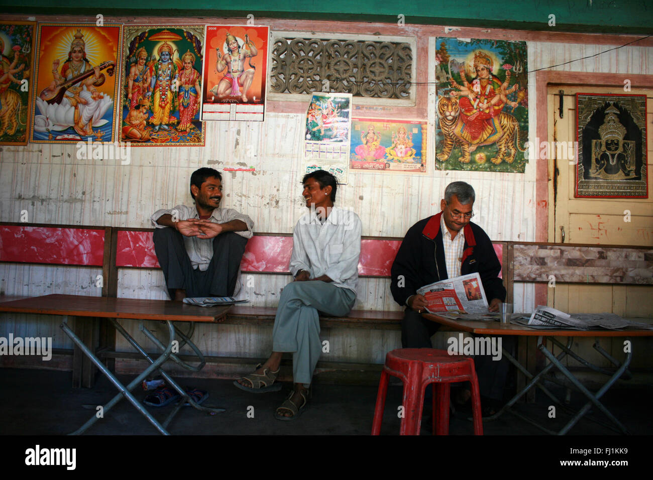 Männer sprechen und lesen Zeitung am Morgen im Café Restaurant in Jaisalmer, Rajasthan, Indien Stockfoto