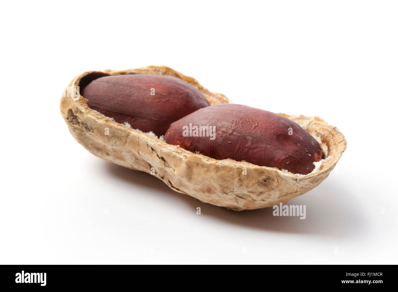 Halb geschälten Erdnüssen auf weißem Hintergrund Stockfoto