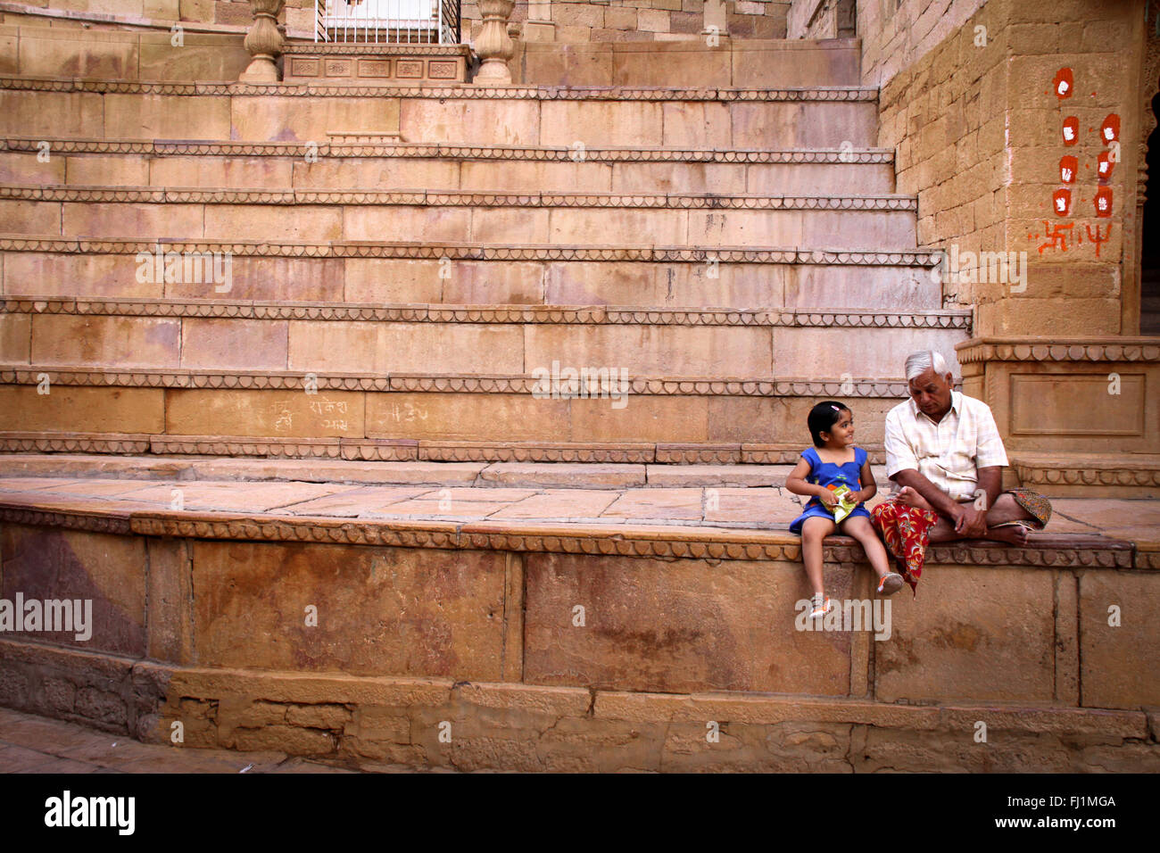 Ein Großvater sitzt mit seiner Enkelin in das Fort von Jaisalmer, mit erstaunlichen Schritte und Architektur, Indien Stockfoto