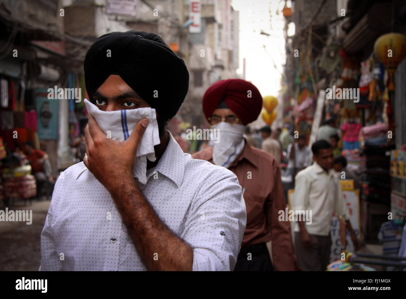 Sikh Männer gehen in einer Straße von Neu Delhi mit Turban und der Deckung ihres faceIndia Stockfoto