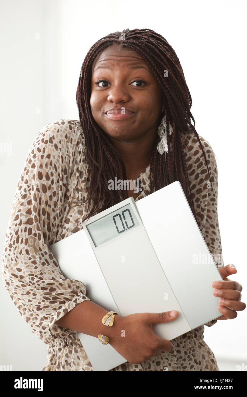 Teenager-Mädchen mit einem lustigen Ausdruck mit einer Skala auf weißem Hintergrund Stockfoto