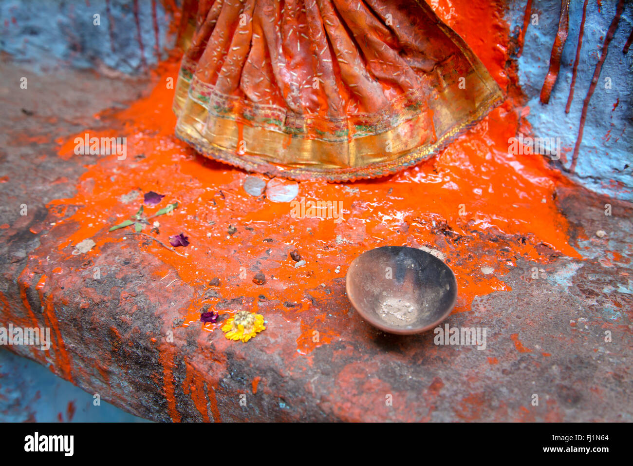 Nahaufnahme auf Rotes Pulver mit Wasser für miwed Puja auf Statue in Varanasi, Indien Stockfoto
