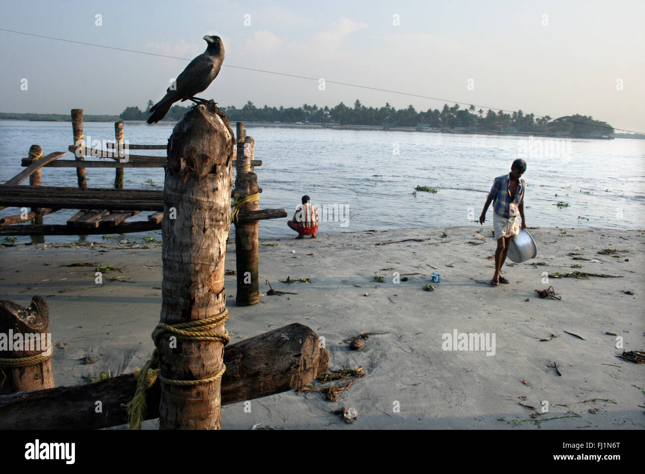 Menschen und Krähe auf den Strand von Fort Kochi, Cochin, Kerala, Indien Stockfoto