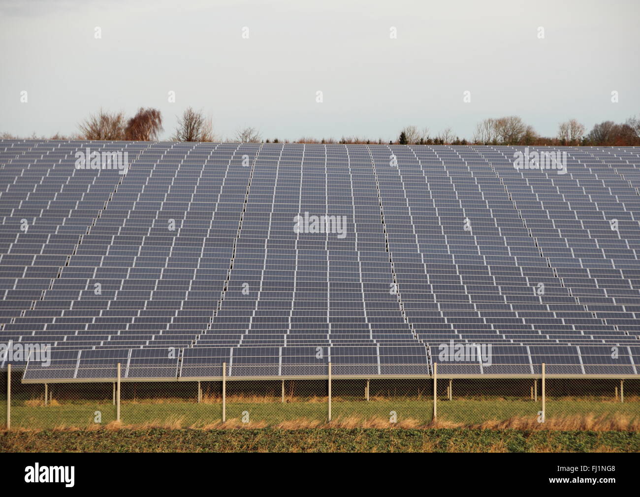 Sun Solar Industrieanlage mit Zaun Rasen und Horizont Stockfoto