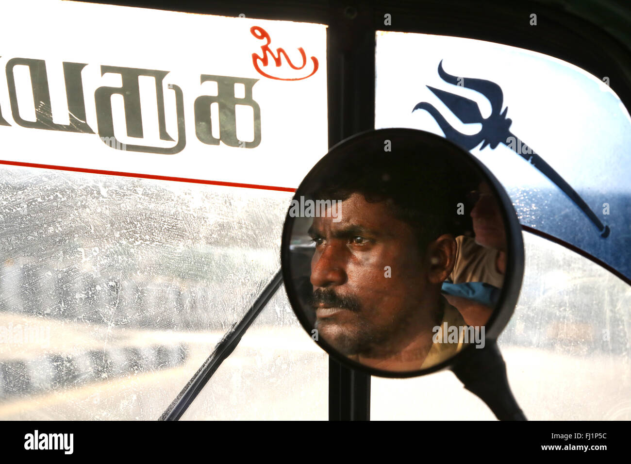 Nahaufnahme auf das Gesicht einer Rikscha Fahrer in Spiegel, Madurai, Indien Stockfoto