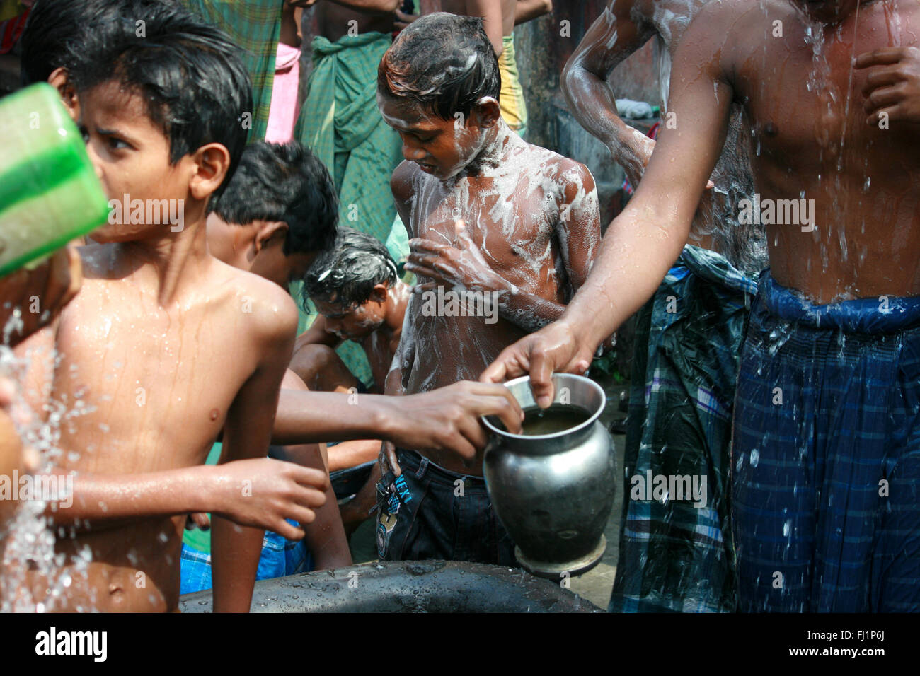 Kinder waschen sich in den frühen Morgen im öffentlichen Duschen in der  Mitte von Kolkata, Indien Stockfotografie - Alamy