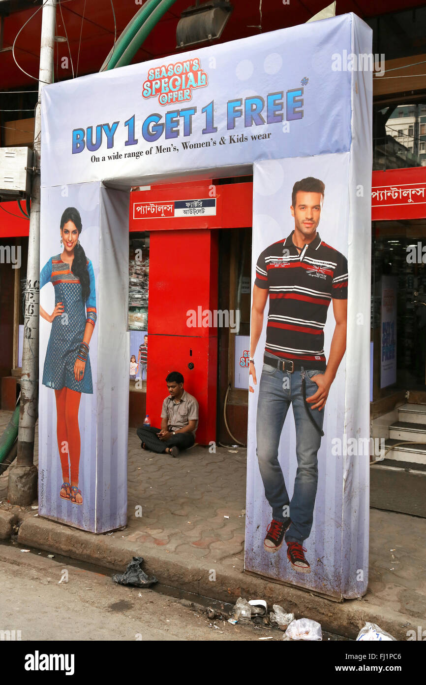 Einsamer Mann sitzt allein vor einem Bekleidungsgeschäft in neuen Marktgebiet, Kolkata, Indien Stockfoto