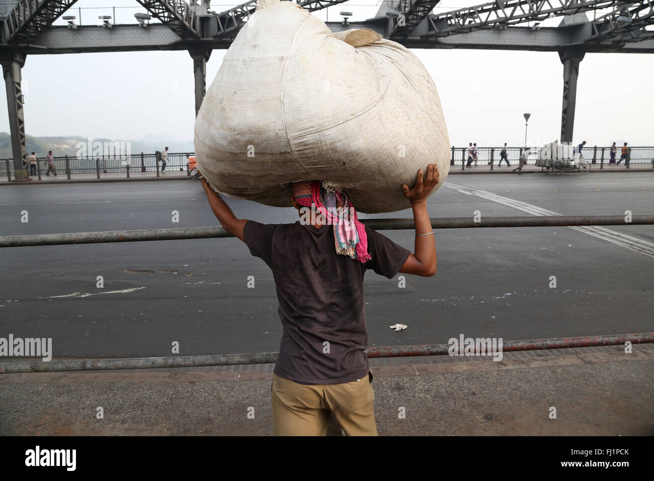 Arbeitnehmer, die schwere Tasche auf Howrah Bridge, Kolkata, Indien Stockfoto