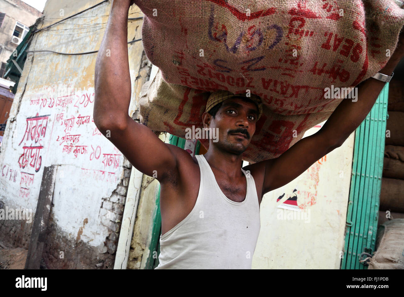 Arbeitnehmer trägt große schwere Tasche in Howrah, Kolkata, Indien Stockfoto