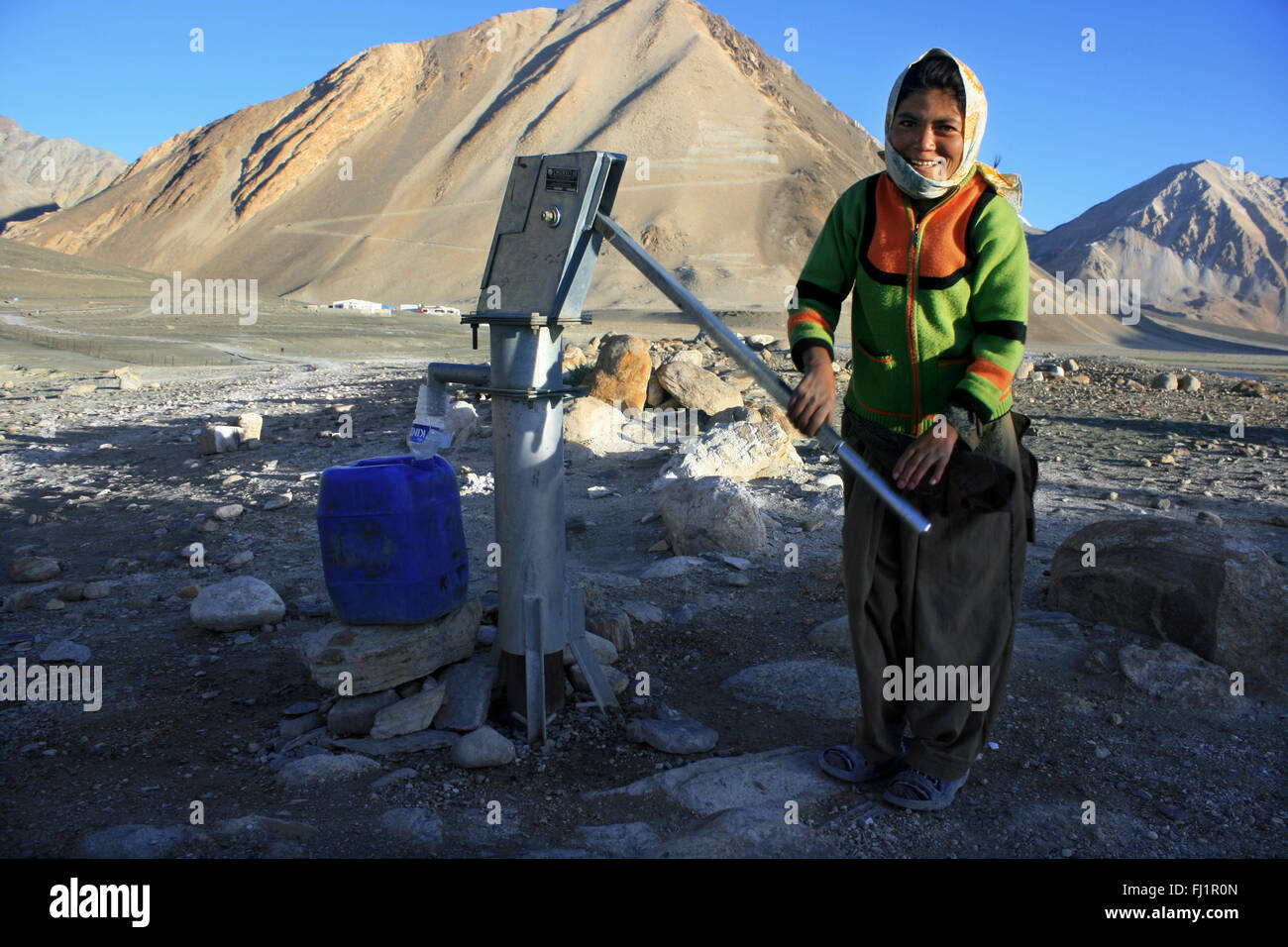 Eine junge ladakhi Mädchen nimmt Wasser in einem gut in den frühen Morgen in der Nähe Pangong Tso See, Ladakh, Indien Stockfoto