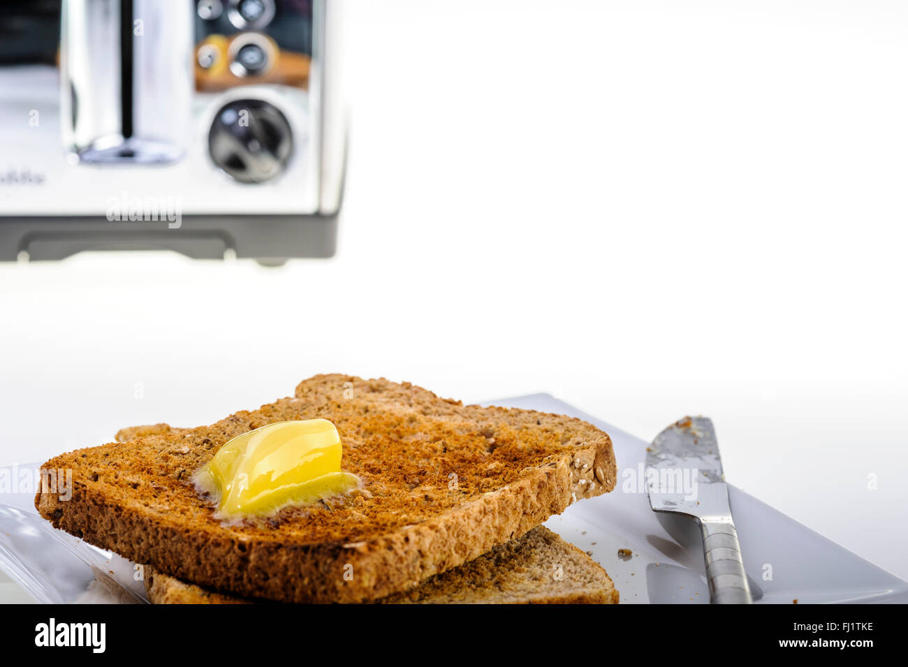 Vier Stück, chrom Toaster mit Toast und Butter. Stockfoto