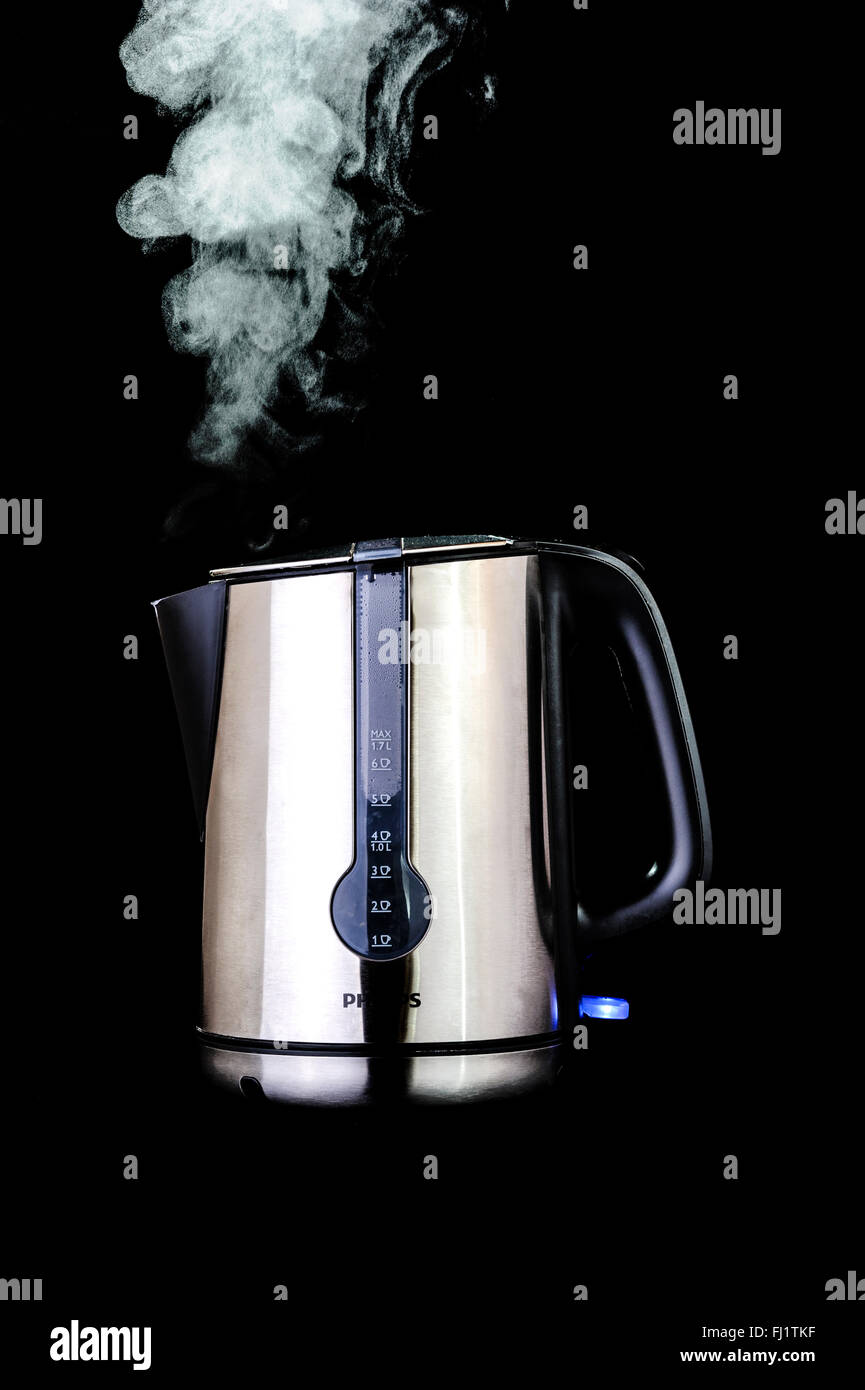 Edelstahl Wasserkocher auf schwarzem Hintergrund, mit Dampf. Stockfoto