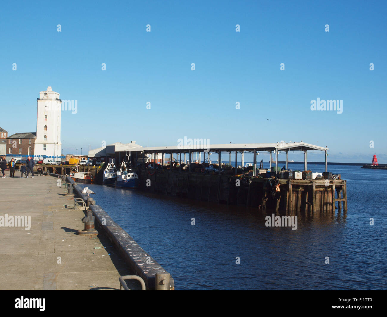 Newcastle Upon Tyne, Sonntag, 28. Februar 2016, Großbritannien Wetter. Sonniger Nachmittag am Eingang zum Fluss Tyne in North Shields Fisch Kai mit der Fischereiflotte entfernt am Meer Angeln. Das 19. Jahrhundert Leuchtturm abgebildet gilt ein paar als die hohe und niedrige leuchtet aufgrund um es geografische Lage in der Nähe und bestimmt waren, als Navigationshilfe für die Schifffahrt, Eintritt in den Fluss Tyne bei der Vermeidung von "Black Muschelhaufen" rockt die liegen knapp unter der Oberfläche, die viele ein Schiff in den Jahren behauptet haben. Stockfoto