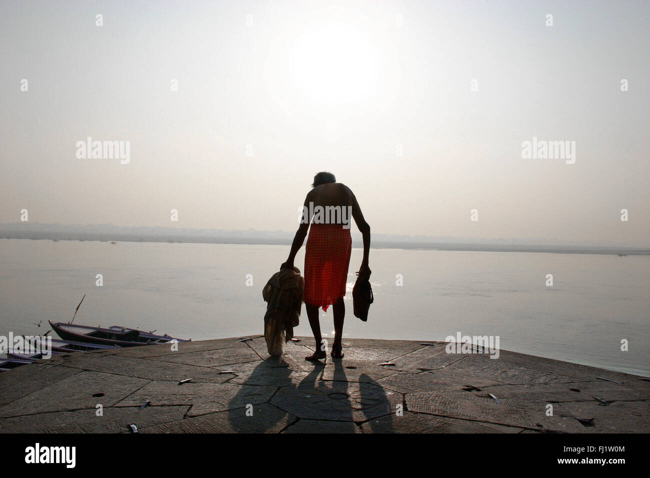 Alter Mann auf einem GHAT von Varanasi am frühen Morgen, Indien Stockfoto