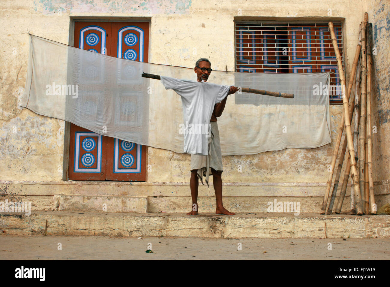 Alter Mann Trocknen von Kleidung auf einem GHAT von Varanasi, Indien Stockfoto