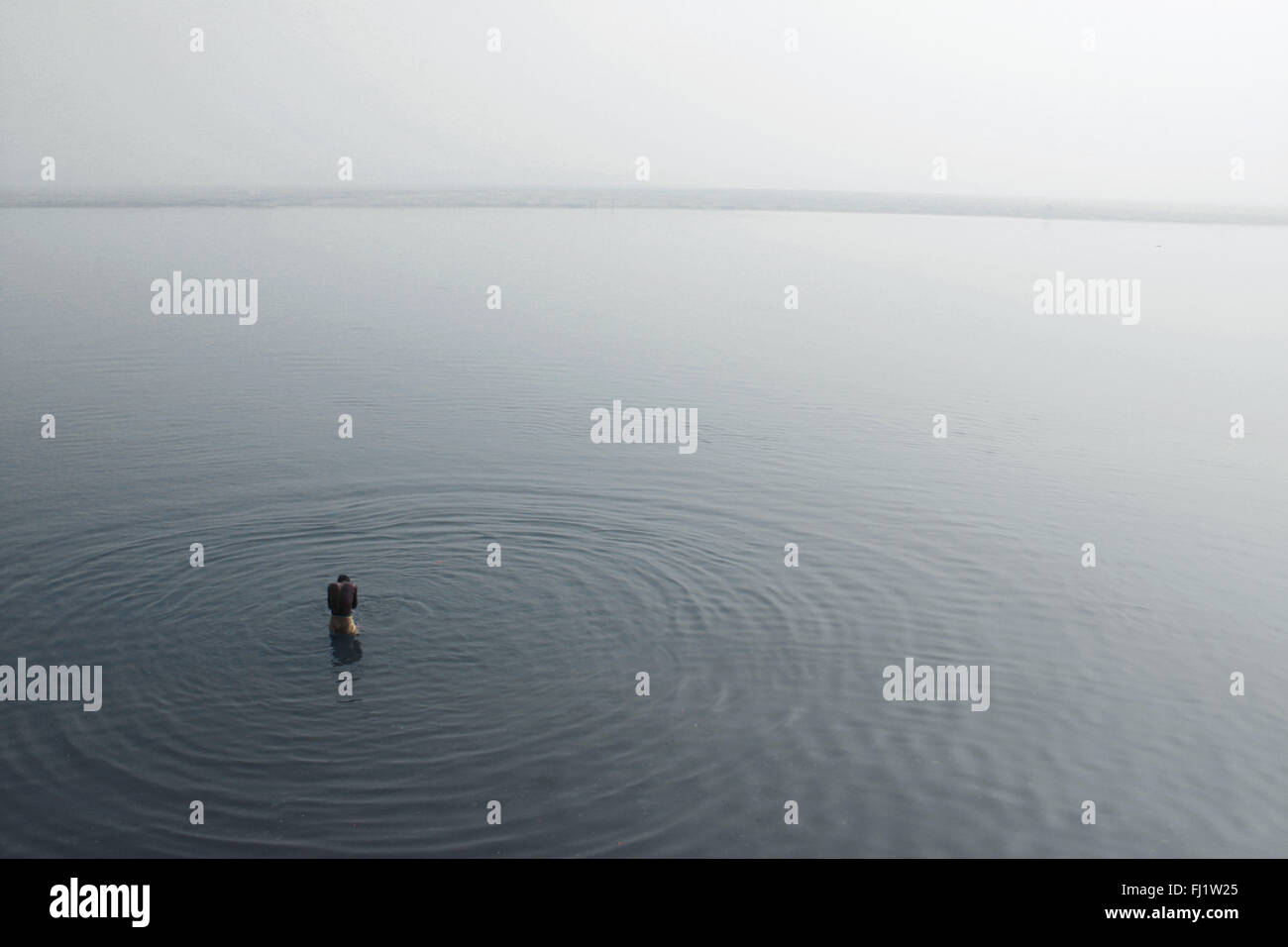 Der Mensch allein im Wasser des Ganges in Varanasi, Indien Beten Stockfoto