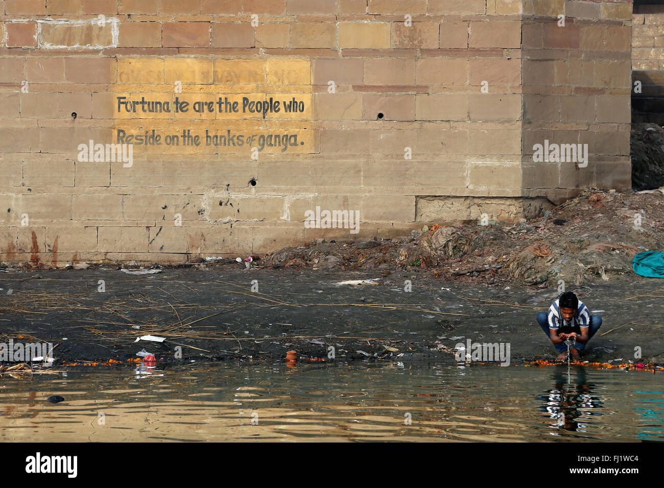 Mann trinken heiligen Wasser in verschmutzten Ganges in Varanasi, Indien Stockfoto