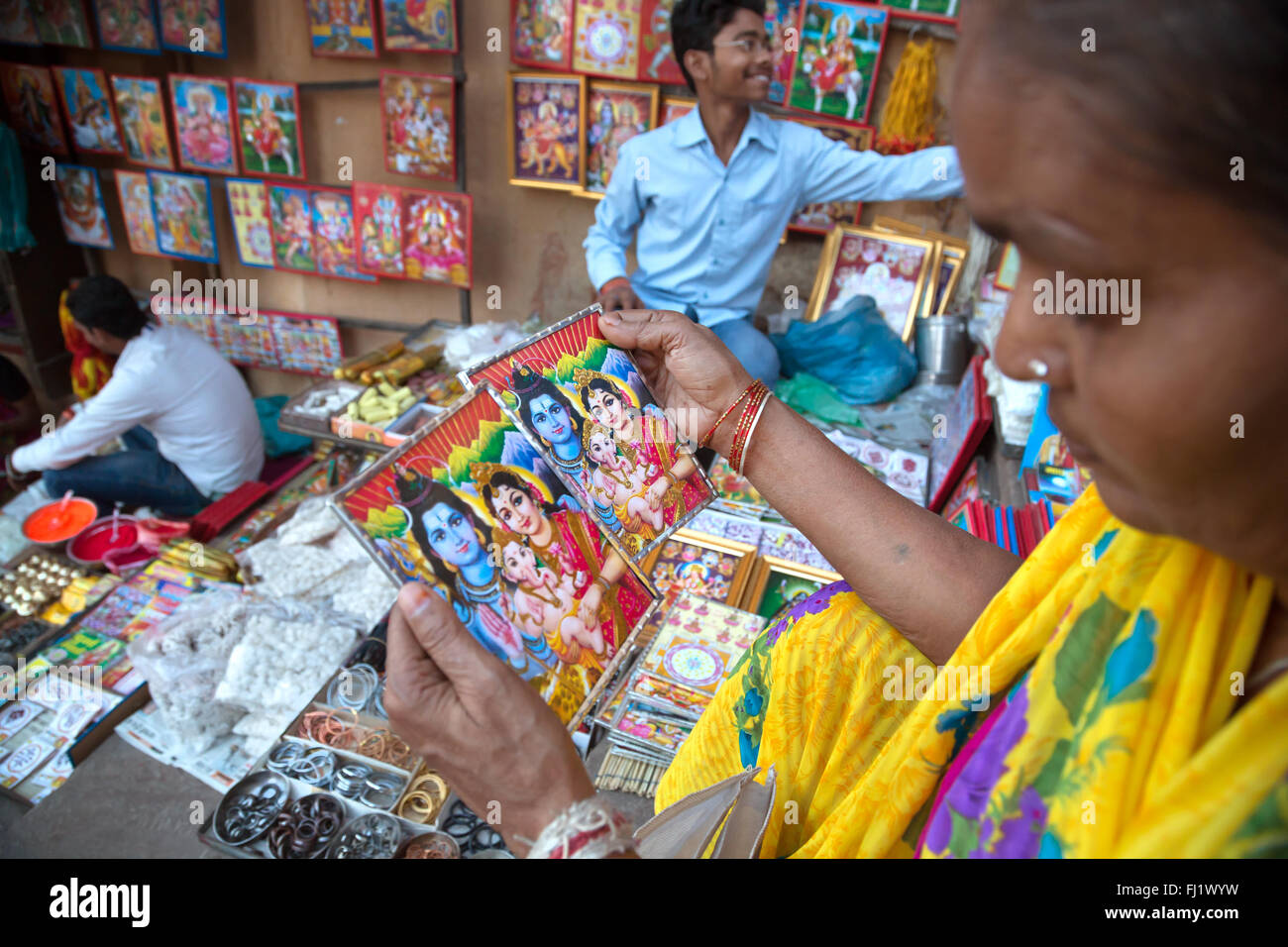 Mann, der Postkarten mit hinduistischen Gogs Shiva, Parvati, Ganesh auf der, auf Dashashwamedh Ghat, Varanasi, Indien Stockfoto