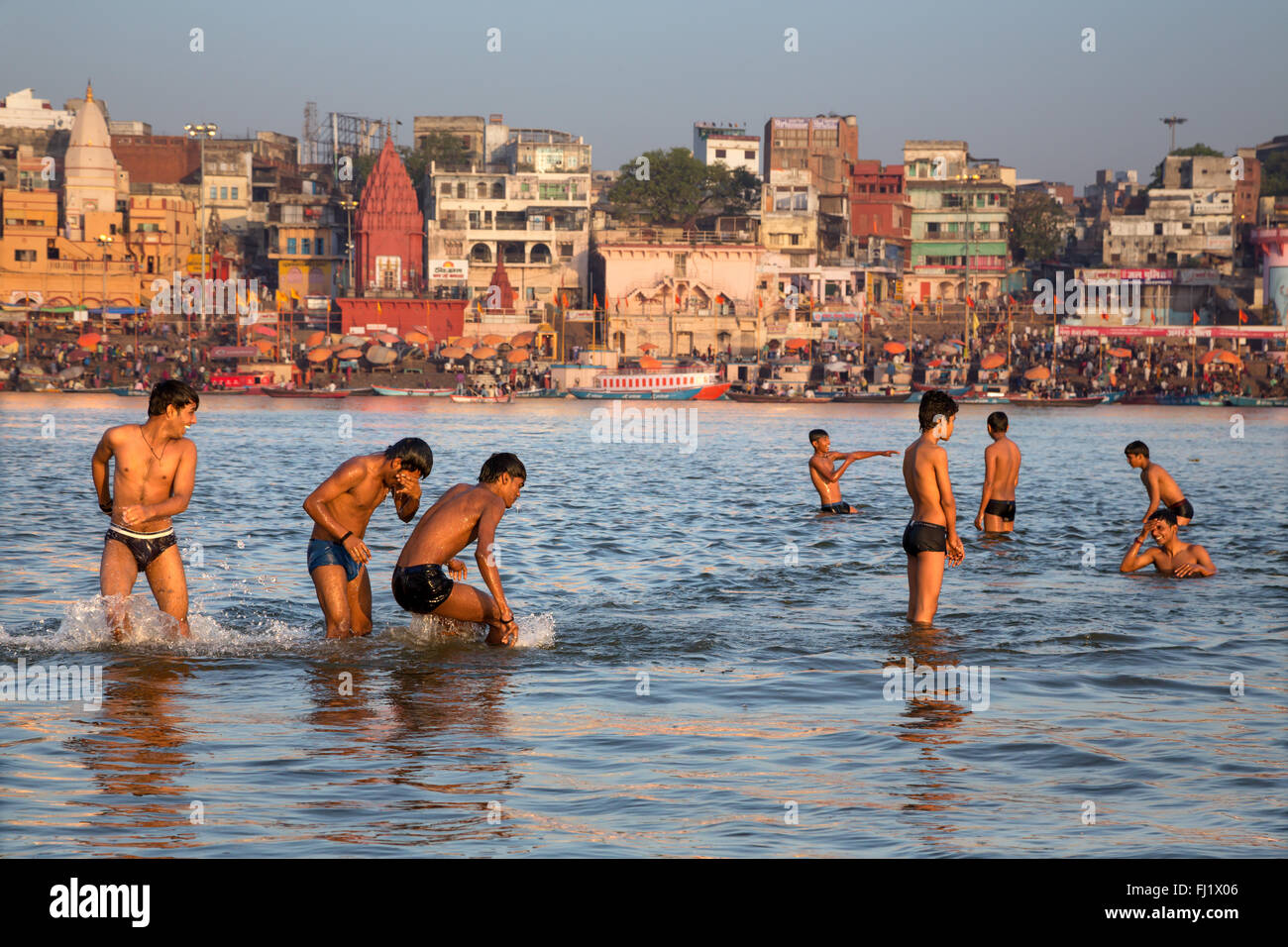Junge Männer spielen im heiligen Wasser des Ganges in Varanasi Stockfoto