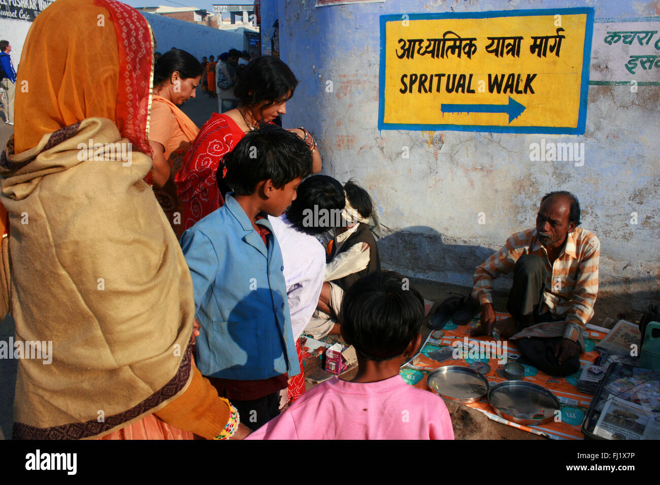 Straßenhändler mit 'spirituelle Spaziergang' Zeichen in einer Straße von Pushkar während Pushkar Mela camel fair, Indien Stockfoto