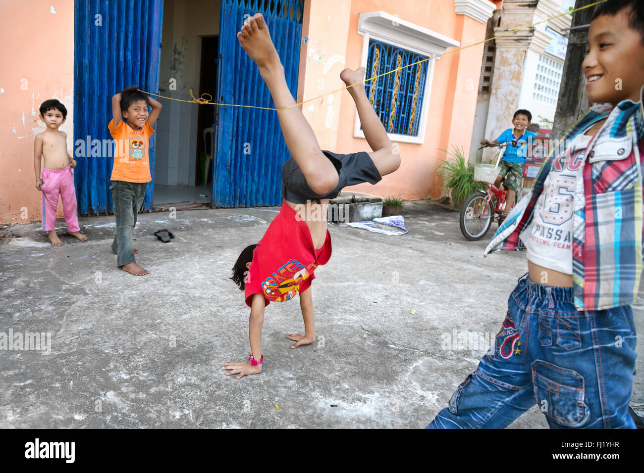 Kinder Bungee Jumping in einer Straße von Kampot, Kambodscha Stockfoto