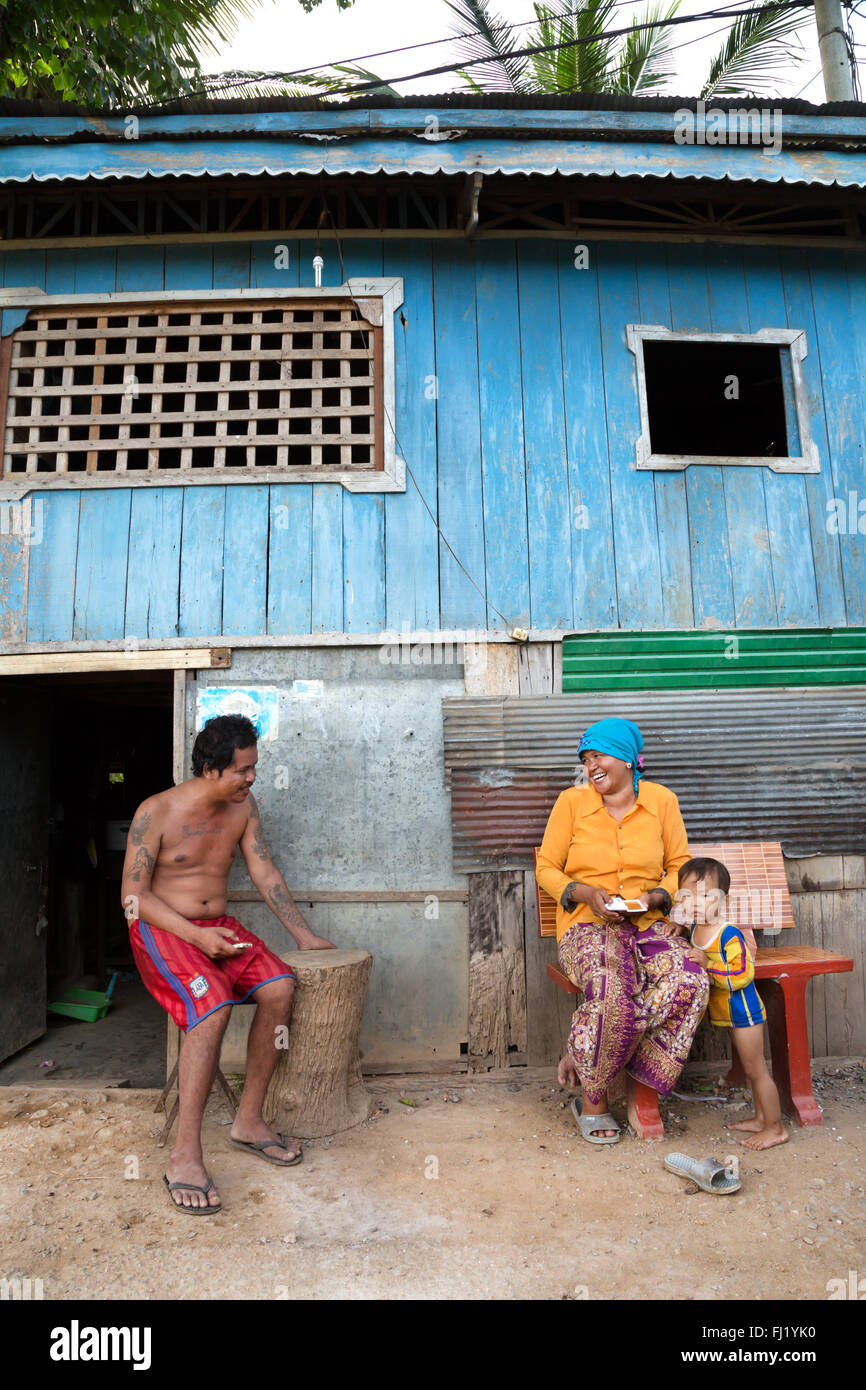 Glückliche Familie vor ihrem Haus in Battambang, Kambodscha sitzen Stockfoto