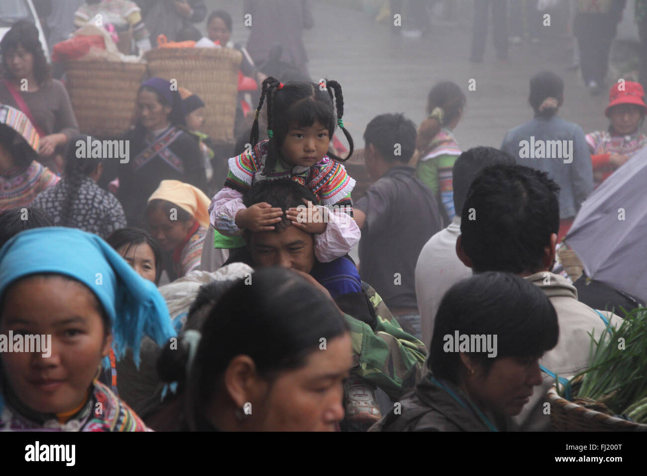 Tribal Mädchen in der Menschenmenge in Yuanyang Markt, Provinz Yunnan, China Stockfoto