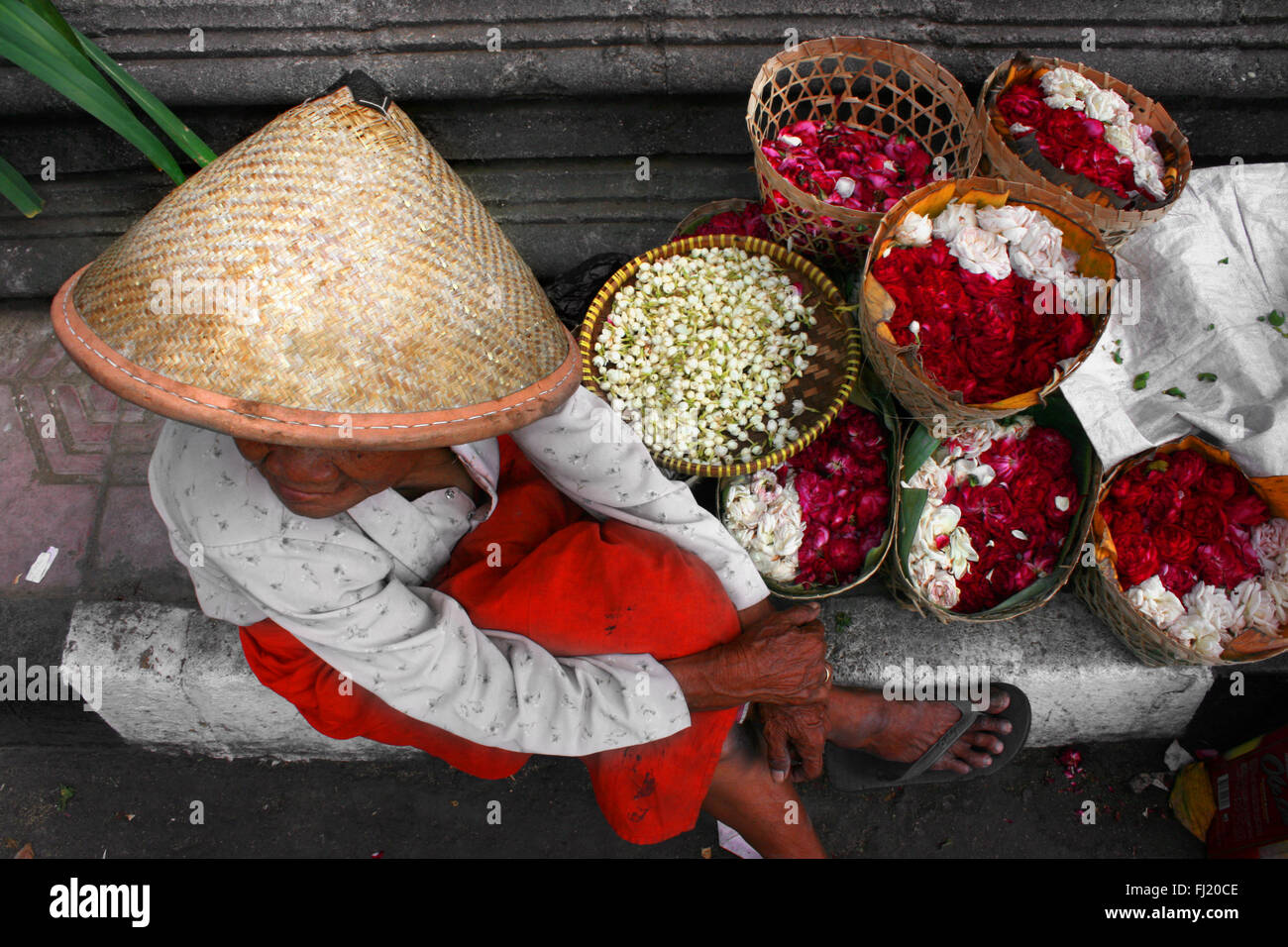 Frau, die Blumen in einer Straße von Yogyakarta Indonesien Stockfoto