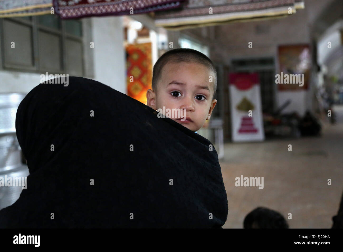 Porträt eines jungen Kindes auf dem Markt von Yazd mit seinen Kopf bedeckte Mutter (HIJAB), Iran Stockfoto