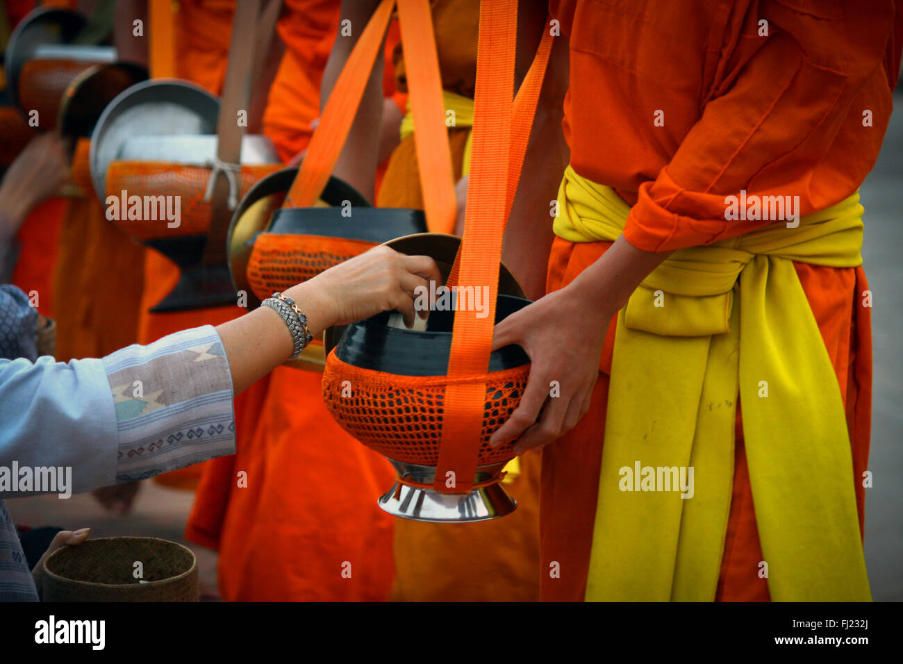 Tak Bat Ritual - Buddhistische Mönche erhalten Reis und Lebensmittel aus pupulation am frühen Morgen in Luang Prabang, Laos, Asien Stockfoto