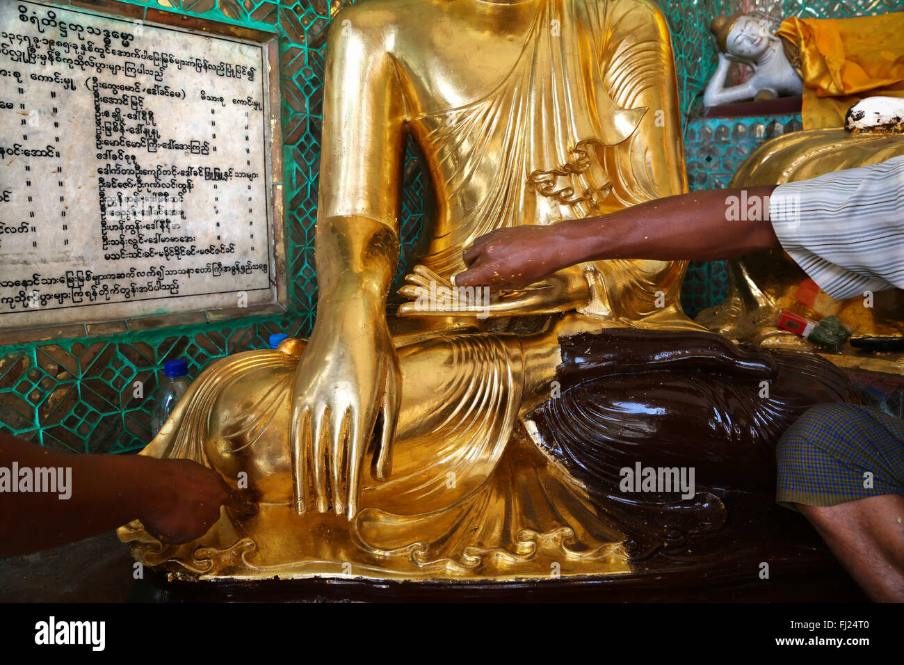 Hände verehren Buddha Statue durch Anwendung goldleaves, innen Shwezigon Pagode, Rangun Stockfoto