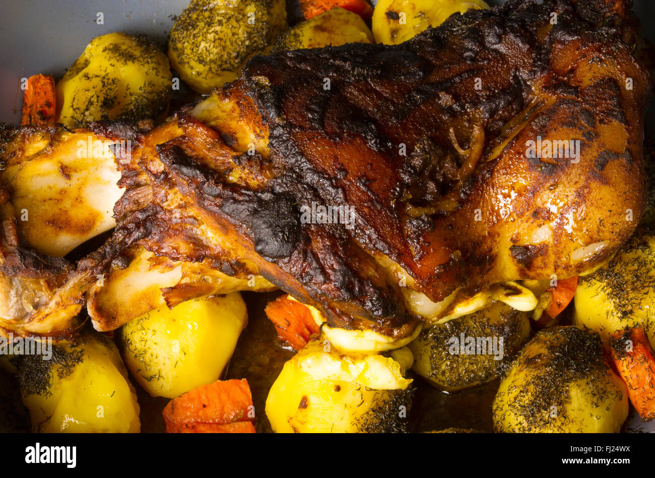 Ofen gebackene Schweinekeule mit Kartoffeln und Gewürzen Stockfoto