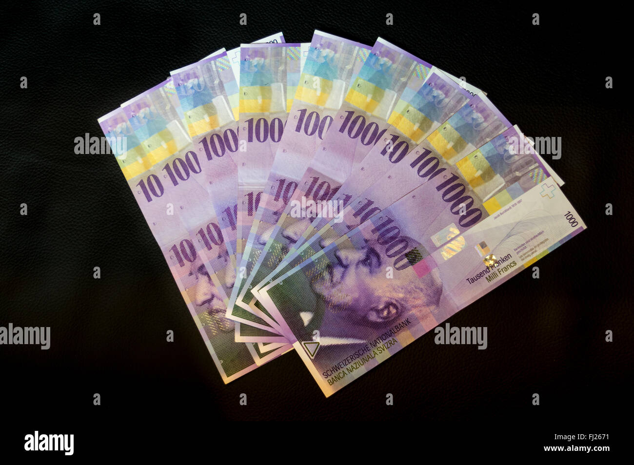 Schweizer 1000 Franken Banknoten als Fan auf schwarzem Hintergrund gezeigt. Die lila Töne verfügen über ein Porträt von Jacob Burckhardt. Stockfoto