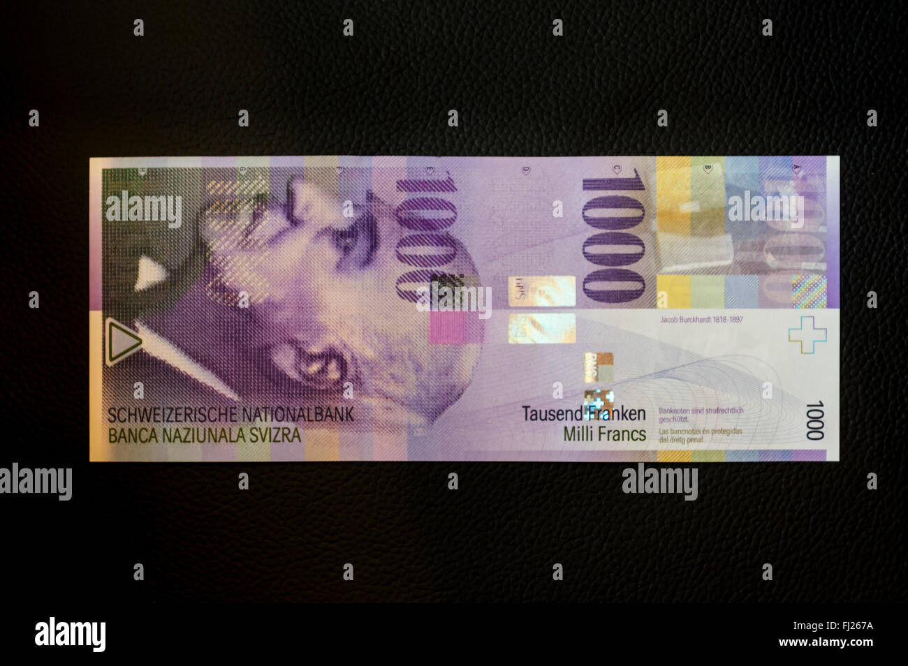1000 Schweizer Franken Banknote auf schwarzem Hintergrund. Die lila Hinweis zeigt ein Porträt von Jacob Burckhardt. Stockfoto