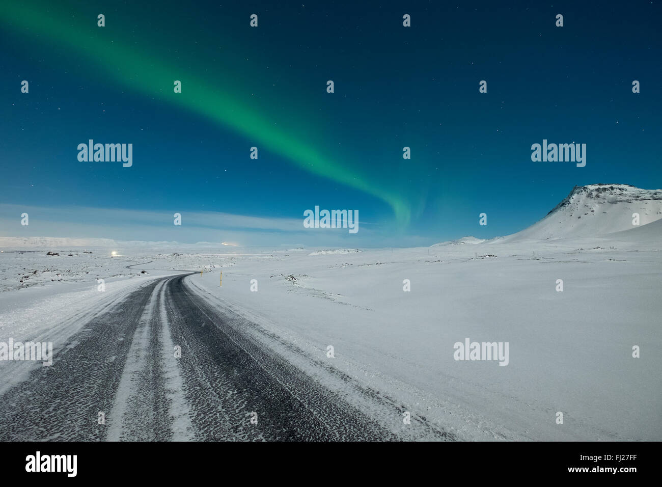 Die Nordlichter tanzen am Himmel über einem gefrorenen Bergstraße Stockfoto