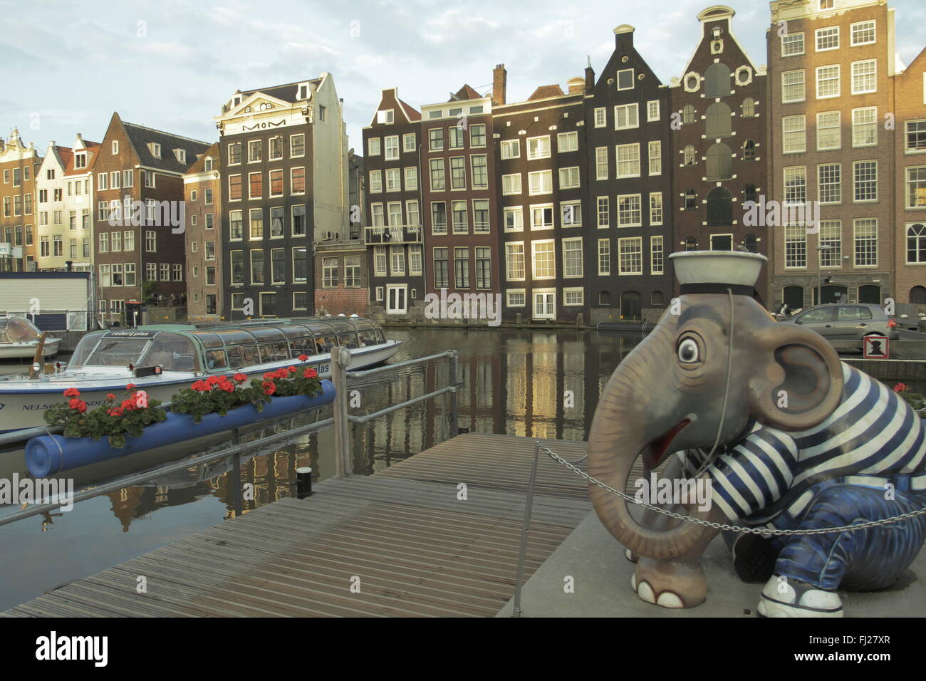 Damrak Kanal im Zentrum von Amsterdam mit einem Boot und typische Architektur im Hintergrund. Stockfoto