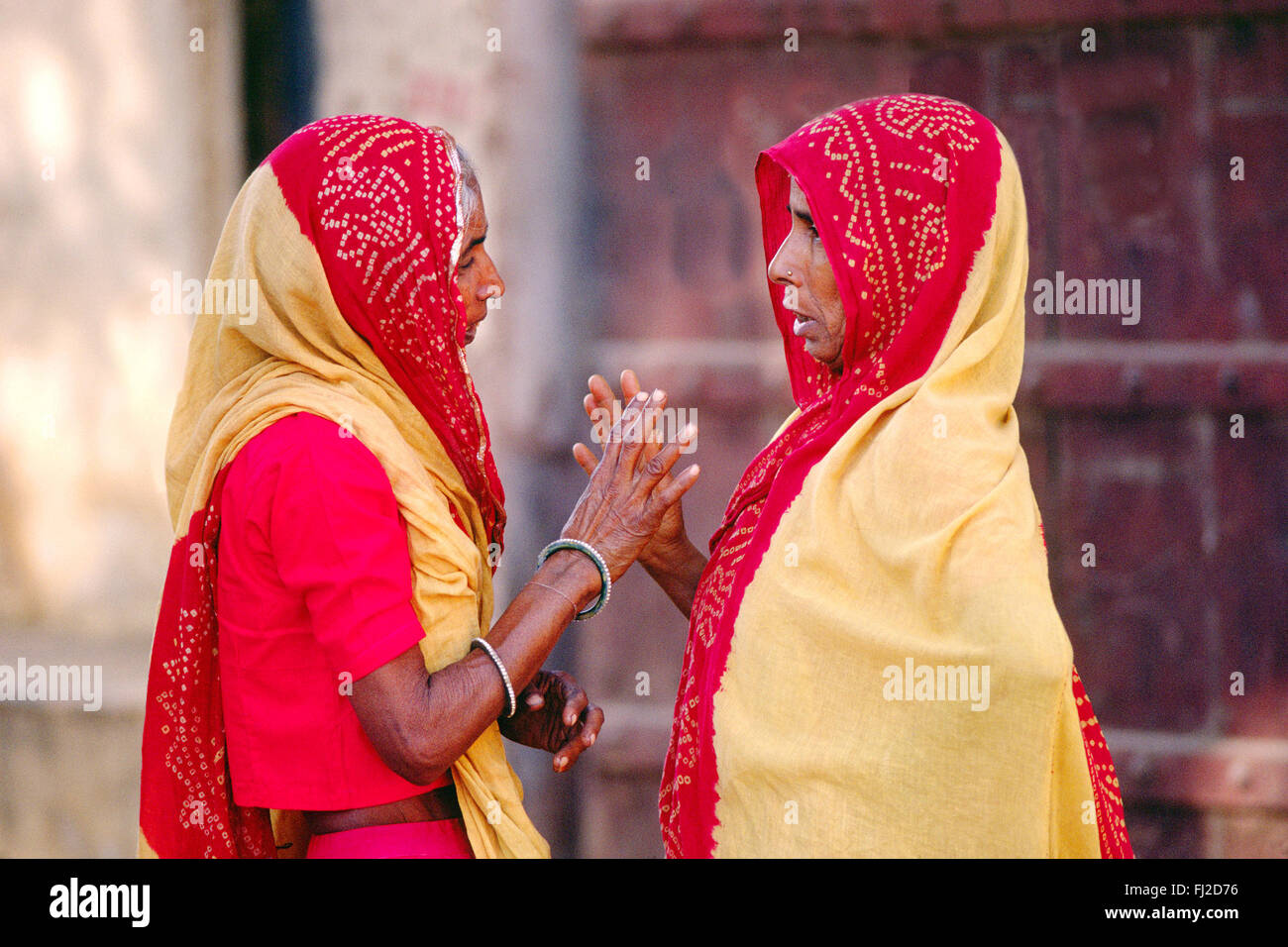 Zwei RAJASTHANI Frauen in traditionellen SARIS haben ein Gespräch in JAIPUR - RAJASTHAN, Indien Stockfoto