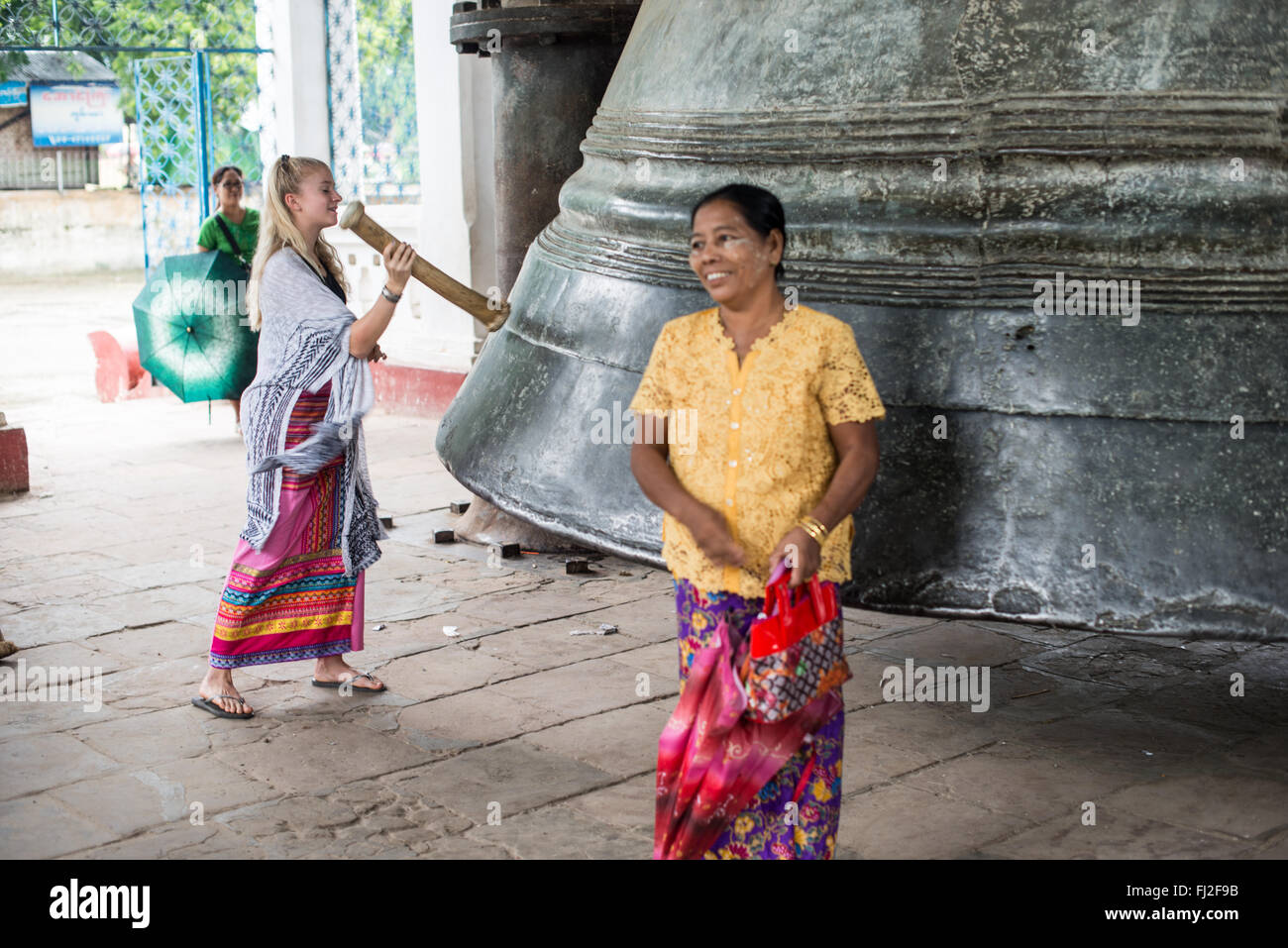 Mingun Bell Mingun Myanmar // MINGUN, Myanmar — Besucher läuten die massive Mingun Bell in ihrem traditionellen Pavillon in der Nähe von Mingun, Myanmar. Sie wurde 1808 während der Regierungszeit von König Bodawpaya gegossen und wiegt etwa 90 Tonnen und gilt weithin als die größte Glocke der Welt. Die riesige Bronzeglocke ist etwa 12 Fuß hoch und 16 Fuß Durchmesser. Die Glocke wurde Anfang des 19. Jahrhunderts als Teil der ehrgeizigen Bauprojekte König Bodawpayas in Auftrag gegeben. Am Ayeyarwady River in der Nähe von Mandalay gelegen, ist die Mingun Bell ein aktives religiöses Artefakt und ein beliebtes Reiseziel Stockfoto