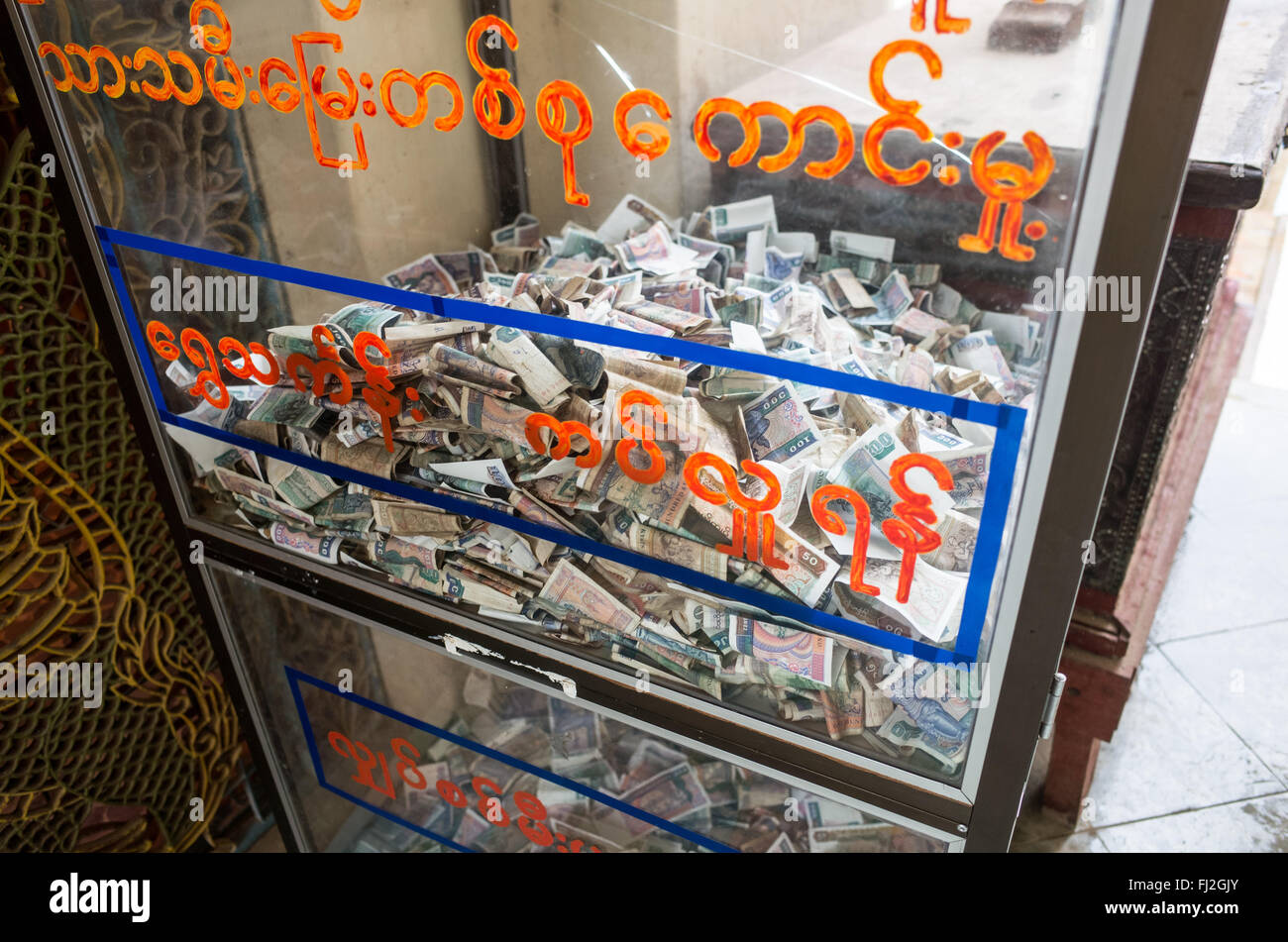 Myazedi Pagoda Spendenbox Myinkaba Myanmar // MYINKABA, Myanmar — Eine Spendenbox befindet sich in der Myazedi Pagoda, einer Stupa aus dem 19. Jahrhundert, die über früheren Ruinen im Dorf Myinkaba in der Nähe von Bagan erbaut wurde. Die Pagode beherbergt einen der bedeutendsten archäologischen Schätze Myanmars, die Myazedi-Inschrift, eine viersprachige Steininschrift aus dem Jahr 1113 n. Chr. in Pali-, Mon-, Alt-Burma- und Pyu-Sprachen. Die Inschrift, die oft Myanmars Rosetta-Stein genannt wird, wurde von Prinz Rajakumar als Gedenkstätte für seine Mutter geschaffen und dokumentiert seine Schenkung von Dörfern und Schätzen für den Bau des nahegelegenen Gubyaukgyi-Tempels. Die Eins Stockfoto