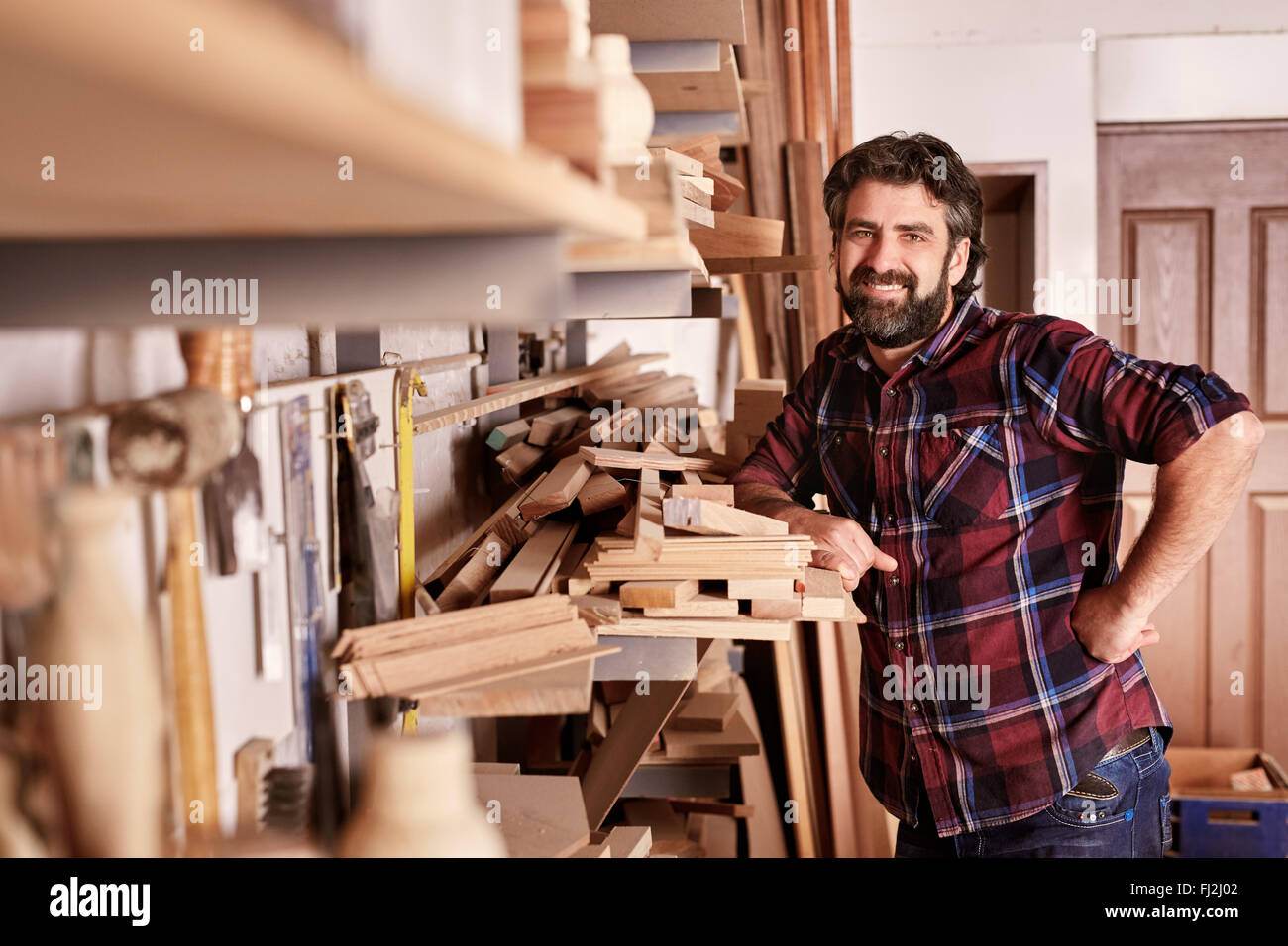 Zimmerei Geschäft Inhaber stand lächelnd in seiner Werkstatt Stockfoto